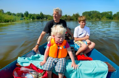 Grandfather with grandchildren on the water clipart