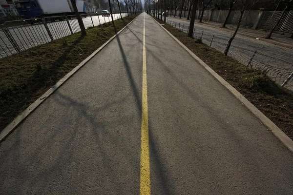 Велосипедный путь с желтой линией на закате — стоковое фото