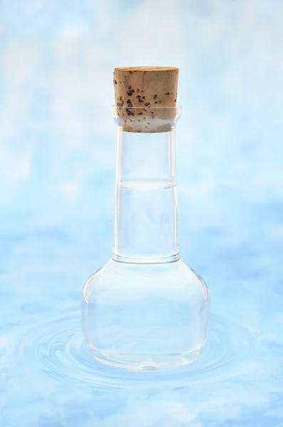 Flasche sauberes Wasser im Wasser plätschert vor farbigem Hintergrund — Stockfoto