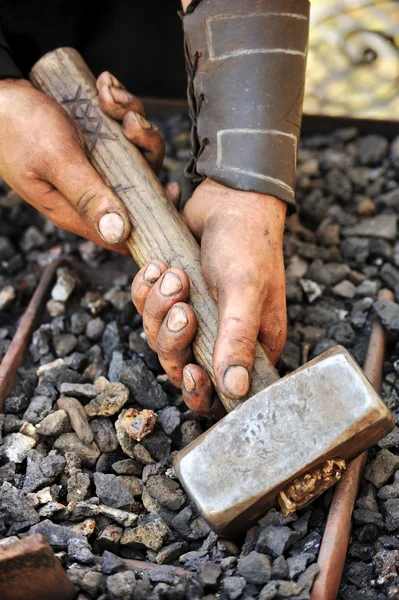 Detalle de manos sucias sosteniendo martillo - herrero — Foto de Stock