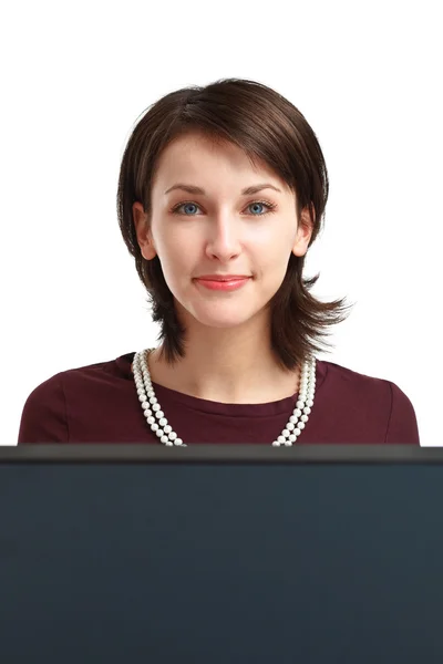Усміхнена молода жінка за комп'ютером — стокове фото