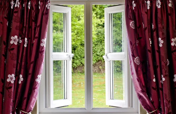 Öppna fönstret draperad i gardiner, med utsikt — Stockfoto