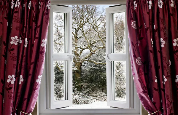 Открытое окно с видом на снежную зимнюю сцену — стоковое фото