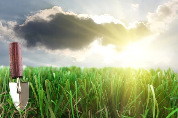 Trawa i kielnia w niebo i słońce tło — Zdjęcie stockowe
