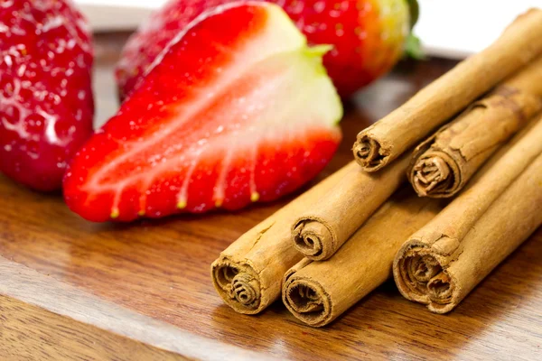Cinnamon sticks and strawberries — Stock Photo, Image