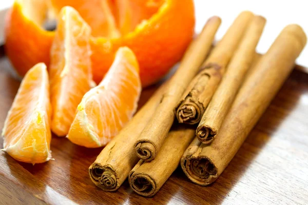 Orange with cinnamon sticks — Stock Photo, Image