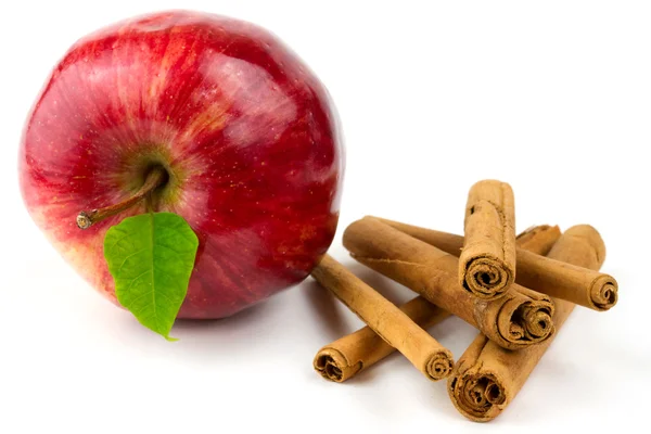 Красное яблоко и коричные палочки — стоковое фото