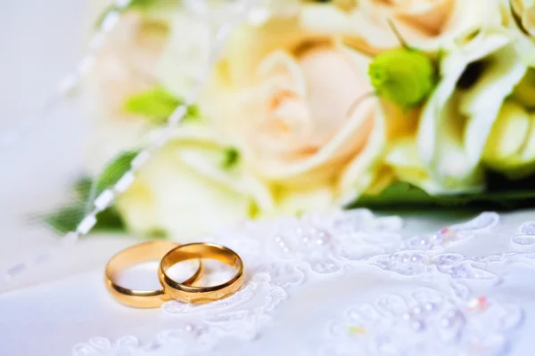 Huwelijksringen met boeket — Stockfoto
