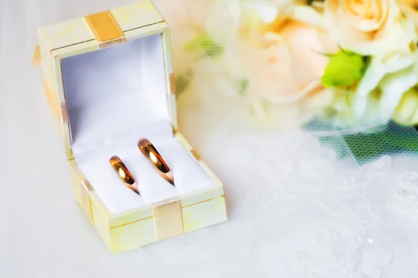 Wedding rings in box with bouquet — Stock Photo, Image