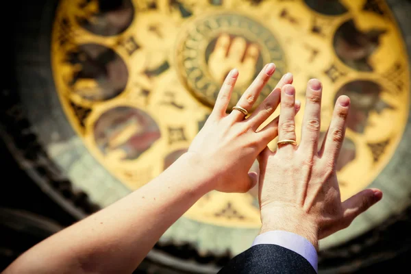 Handen van onlangs getrouwd op Klok achtergrond — Stockfoto