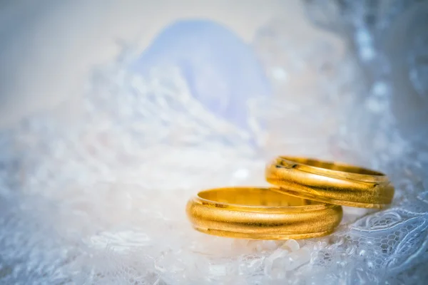 Złote obrączki ślubne na koronki — Zdjęcie stockowe