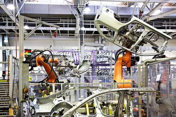 Braços robóticos em uma fábrica de carros — Fotografia de Stock