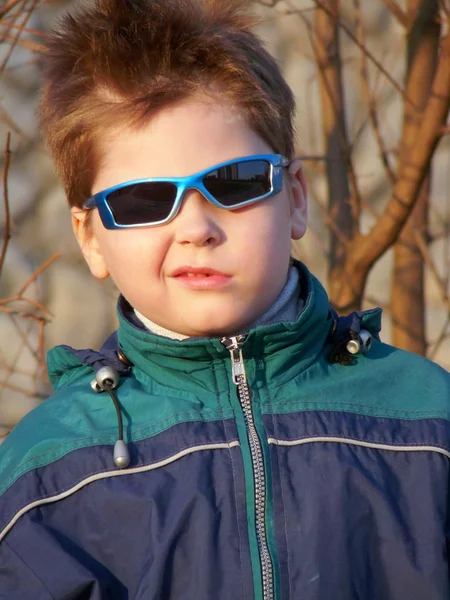 Chłopiec w okularach, z grymasem na twarzy — Zdjęcie stockowe