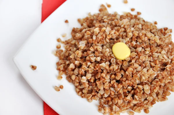 Appetitoso grano saraceno friabile con burro su sfondo bianco — Foto Stock