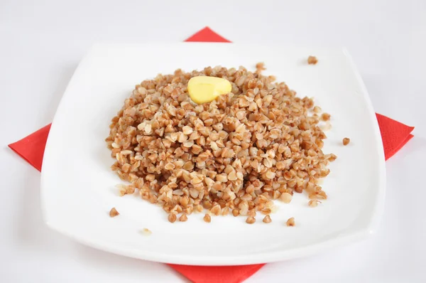 Appetizing crumbly buckwheat with butter on white background — Stock Photo, Image