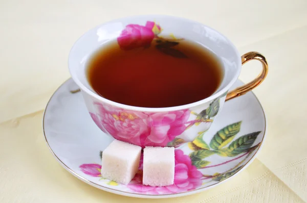 Una taza de té y azúcar en aislamiento sobre un fondo blanco — Foto de Stock