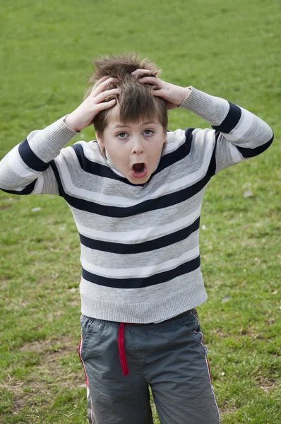 Känslomässiga pojke skriker och håller hans huvud — Stockfoto