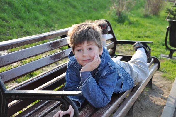 Il ragazzo giaceva su una panchina del parco — Foto Stock