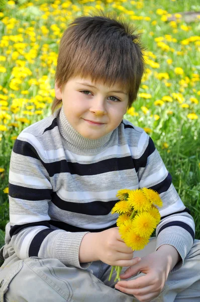 Chłopiec z bukietem mniszek lekarski — Zdjęcie stockowe