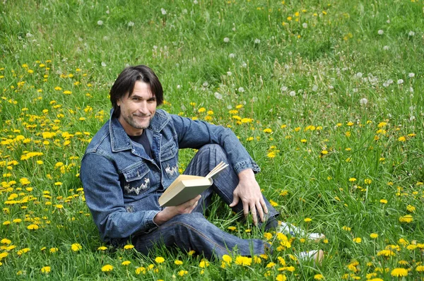 Ένας άνθρωπος διαβάζει ένα βιβλίο στο πάρκο — Φωτογραφία Αρχείου