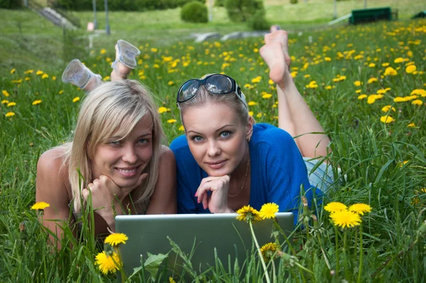 Dos niñas estudiante con un ordenador portátil en el parque — Foto de Stock