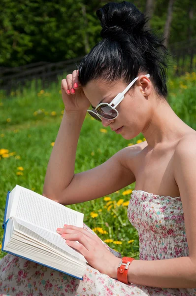 Fiatal nő olvas egy könyvet a parkban — Stock Fotó