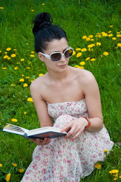 Jeune femme lisant un livre dans le parc — Photo