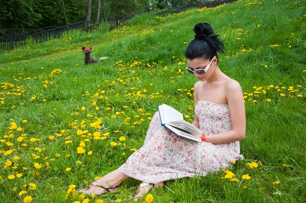 Młoda kobieta czytająca książkę w parku — Zdjęcie stockowe