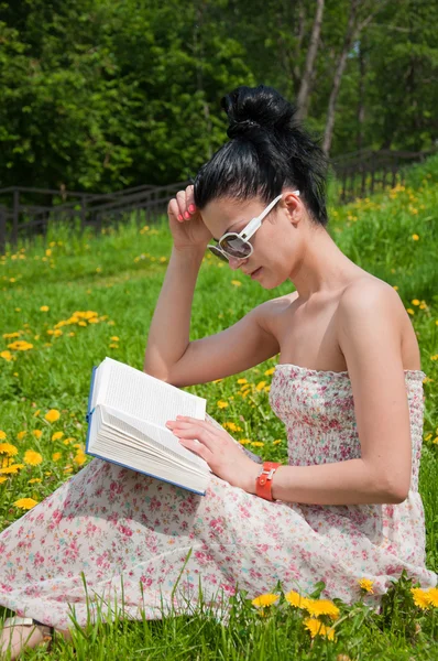 Молода жінка читає книгу в парку — стокове фото