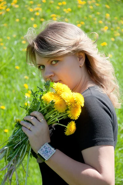 Portrét mladé dívky, na trávníku s kyticí pampelišky — Stock fotografie