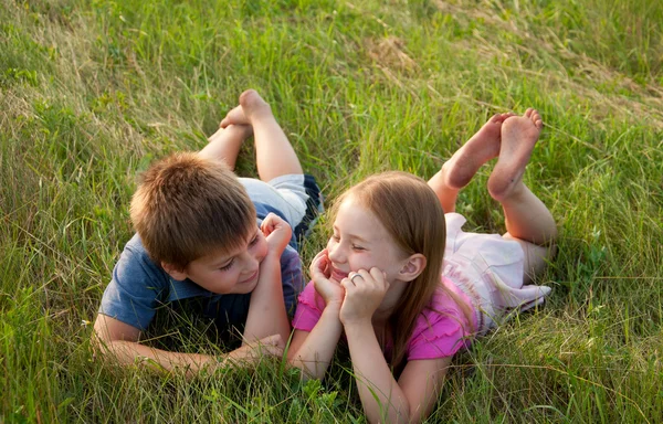 Zabawny chłopak i dziewczyna leżąc na trawie — Zdjęcie stockowe