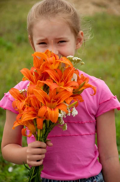 Menina com um buquê de lírios laranja — Fotografia de Stock