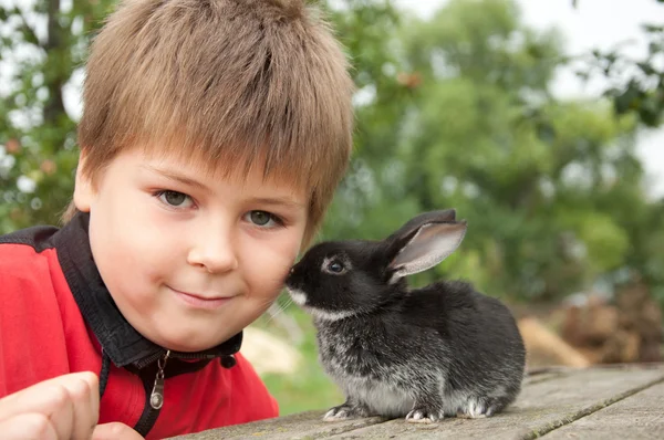 stock image A boy with a rabbit in the garden at the cottage