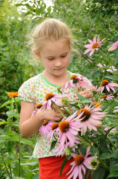 Mooi meisje permanent in de bloemen — Stockfoto