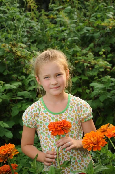 Schönes Mädchen, das in den Blumen steht — Stockfoto