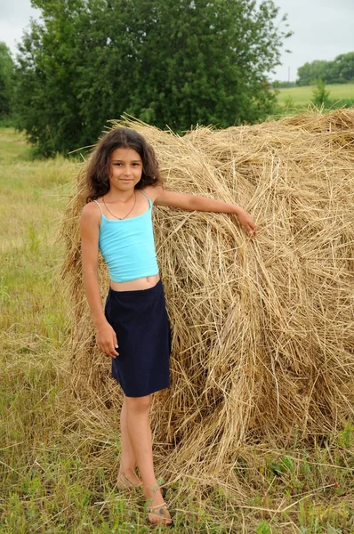 Красива дівчина в полі на фоні соломи — стокове фото
