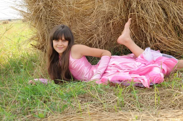 Krásná dívka v poli na pozadí ze slámy — Stock fotografie