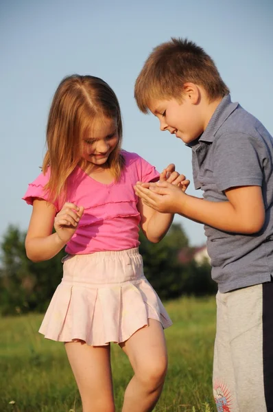 Мальчик и девочка на траве летом — стоковое фото