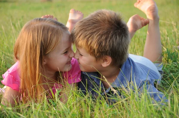 Chłopiec i dziewczynka na trawie w okresie letnim — Zdjęcie stockowe