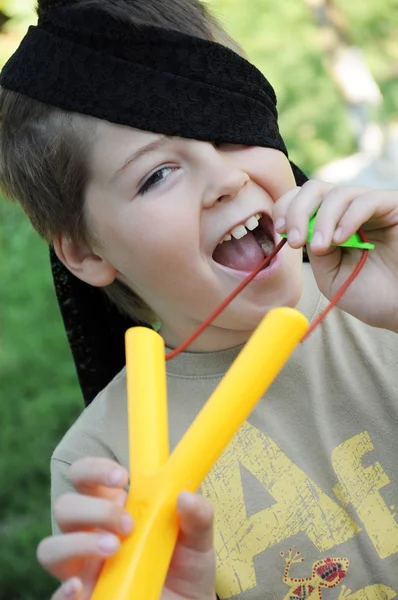 Um menino brinca com uma catapulta canhota — Fotografia de Stock