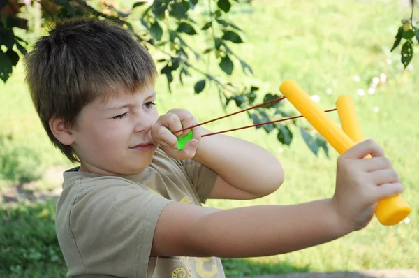 En pojke leker med en vänsterhänt katapult — Stockfoto
