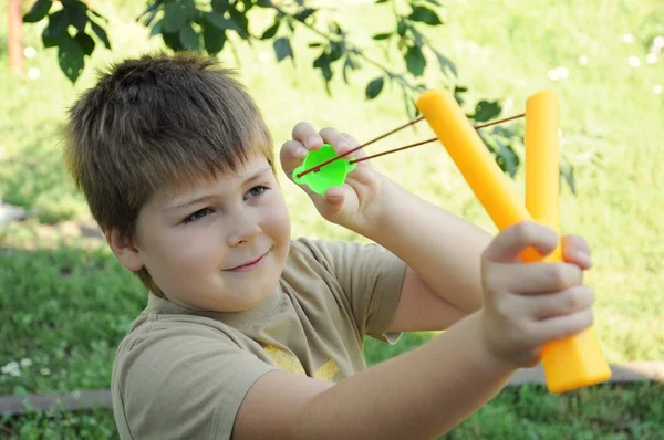 En pojke leker med en vänsterhänt katapult — Stockfoto