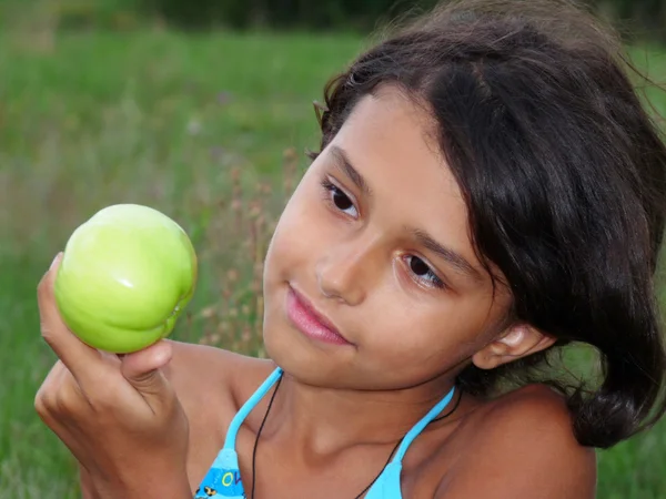 Uma menina bonita com uma deliciosa maçã verde — Fotografia de Stock