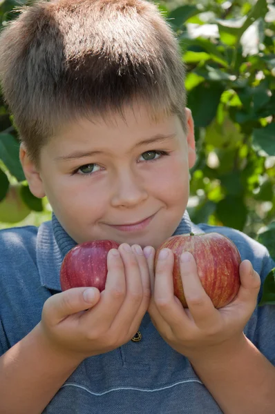 Un ragazzo con una deliziosa mela rossa — Foto Stock