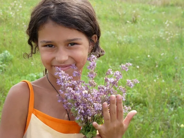 En vacker flicka med en bukett av blommor — Stockfoto