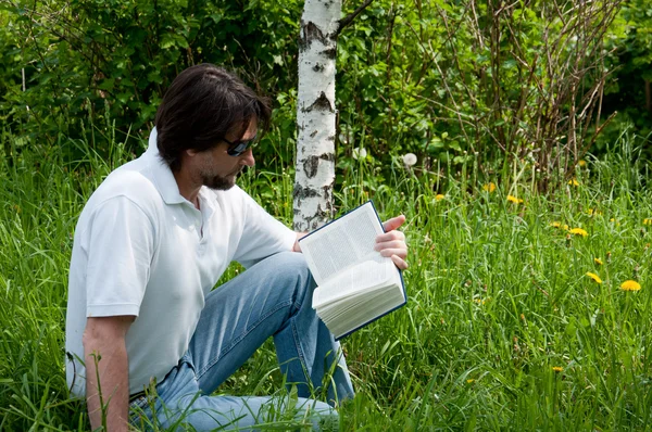 Un homme lit un livre dans le parc — Photo