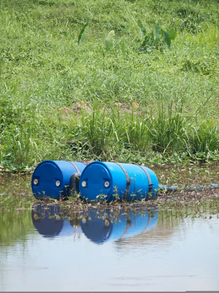 stock image Blue toxic drums in river