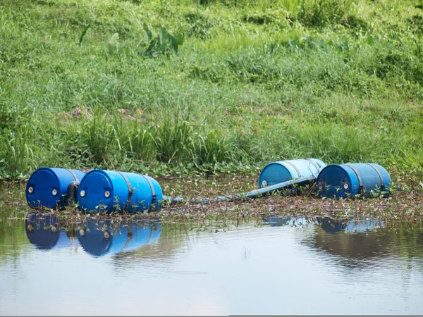 Blauwe giftige drums in rivier — Stockfoto