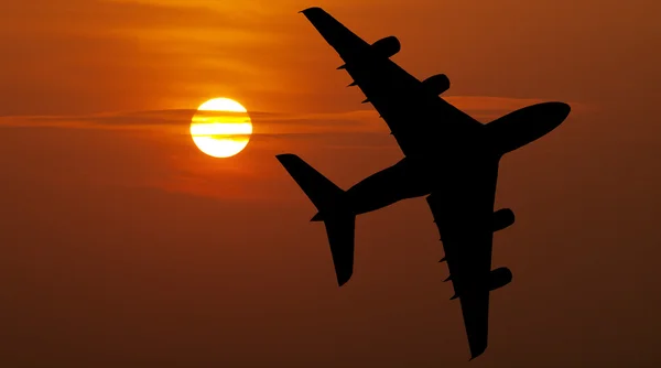 Vliegtuig over rode zonsondergang — Stockfoto