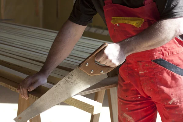 Carpintero cortar una tabla de madera —  Fotos de Stock